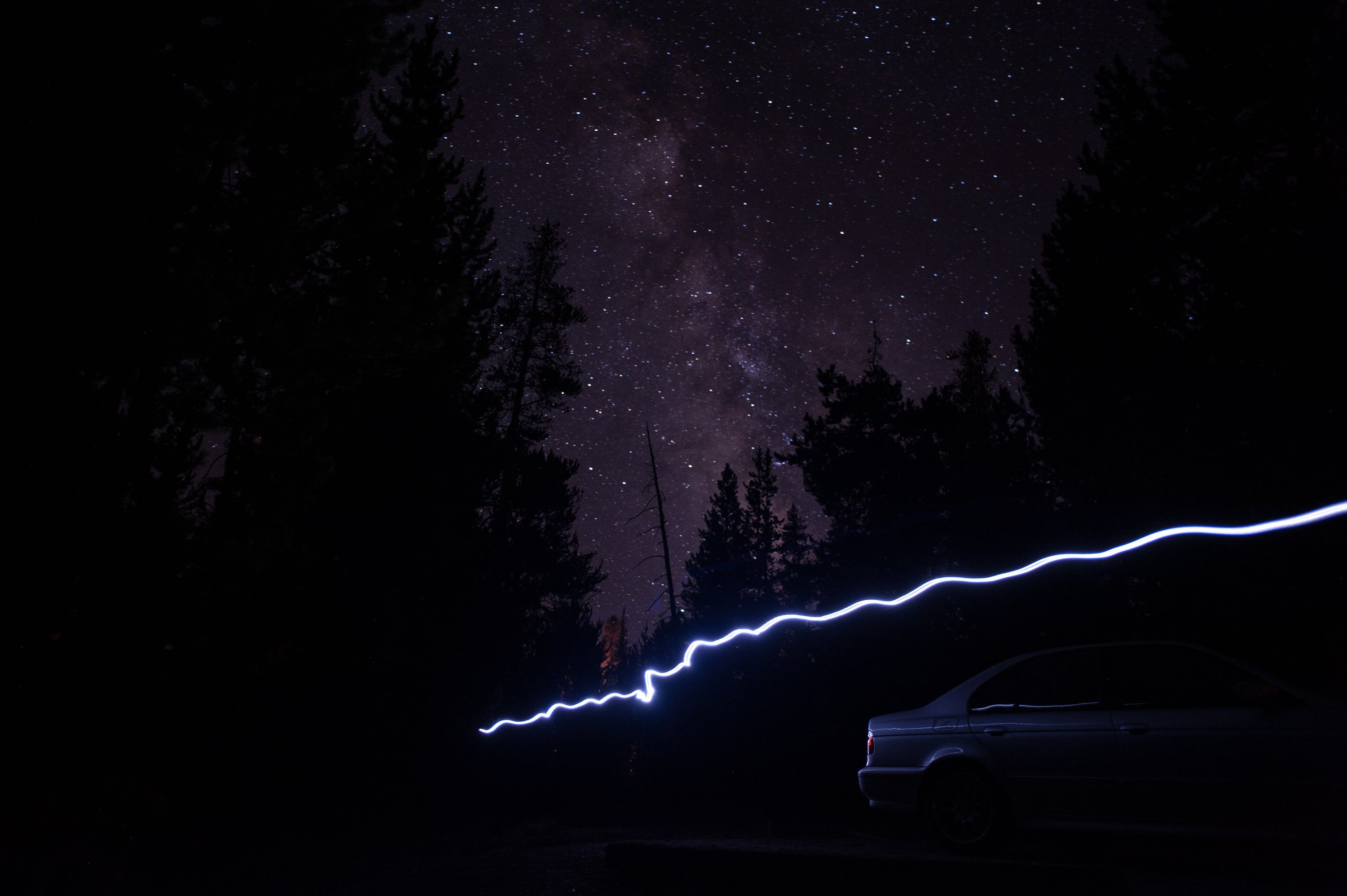 One frame from the sequence: a streak of light across the frame, and the car lit by it for a moment.